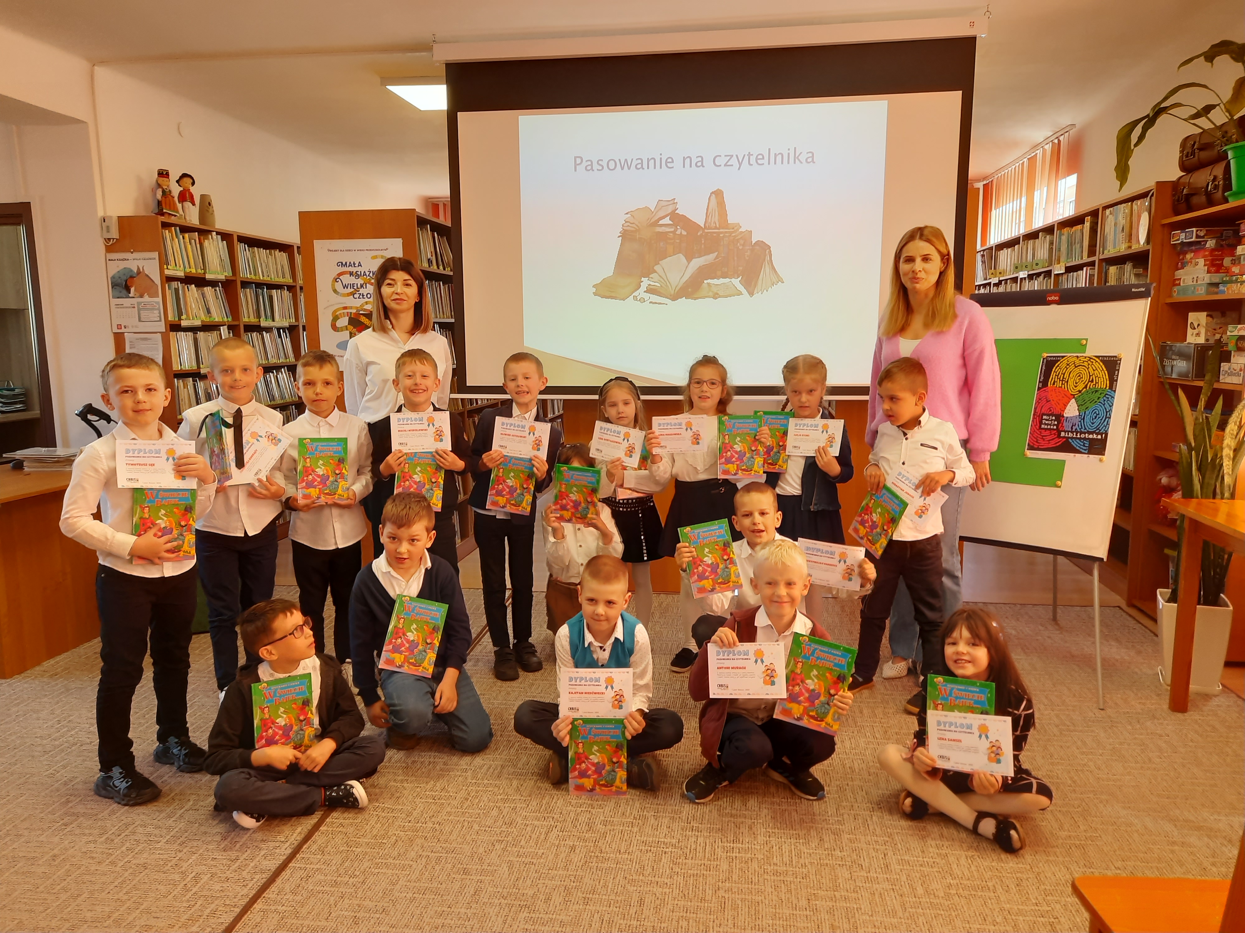 Pamiątkowe_zdjęcie_pierwszoklasist&oacute;w_z_wychowawczynią_Marzeną_Przeradzką_i_pracownikiem_biblioteki_-_Michaliną_Kurpiewska-