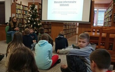 Bibliotekarka opowiada o działalności biblioteki