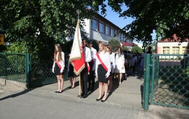 Poczet Sztandarowy  i społeczność szkolna w drodze ze szkoły do kościoła