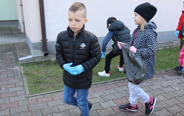 Uczniowie klasy Ia sprzątają koło szkoły.