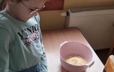 Maja z kl. Ia odmierza składniki ciastoliny.
