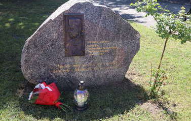 Obelisk przed budynkiem szkoły poświęcony Patronowi.