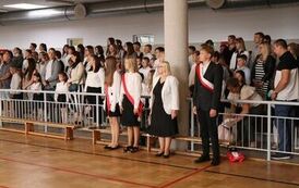 Poczet sztandarowy wraz z opiekunem Jolantą Chmielewską, w tle uczniowie z rodzicami